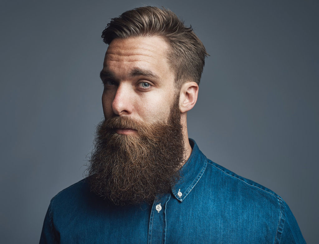 bearded-young-hipster-standing-alone-against-a-gray-background.jpg